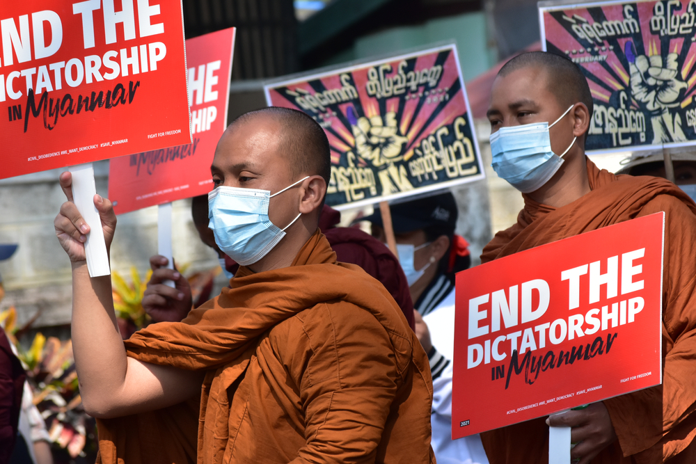 Protestierende Mönche in Gewändern und mit Schildern