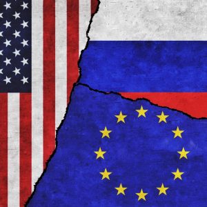 Flaggen von USA, Russland und der EU an einer Wand mit einem Riss