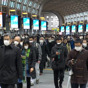 Menschenmenge im Bahnhof Shinagawa in der Rushhour mit Maske.
