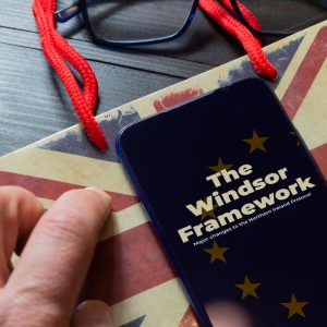 Smartphone mit "The Windsor Framework"-Schriftzug auf britischer Flagge liegend