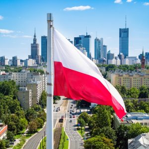 Polnische Flagge vor Warschauer Skyline
