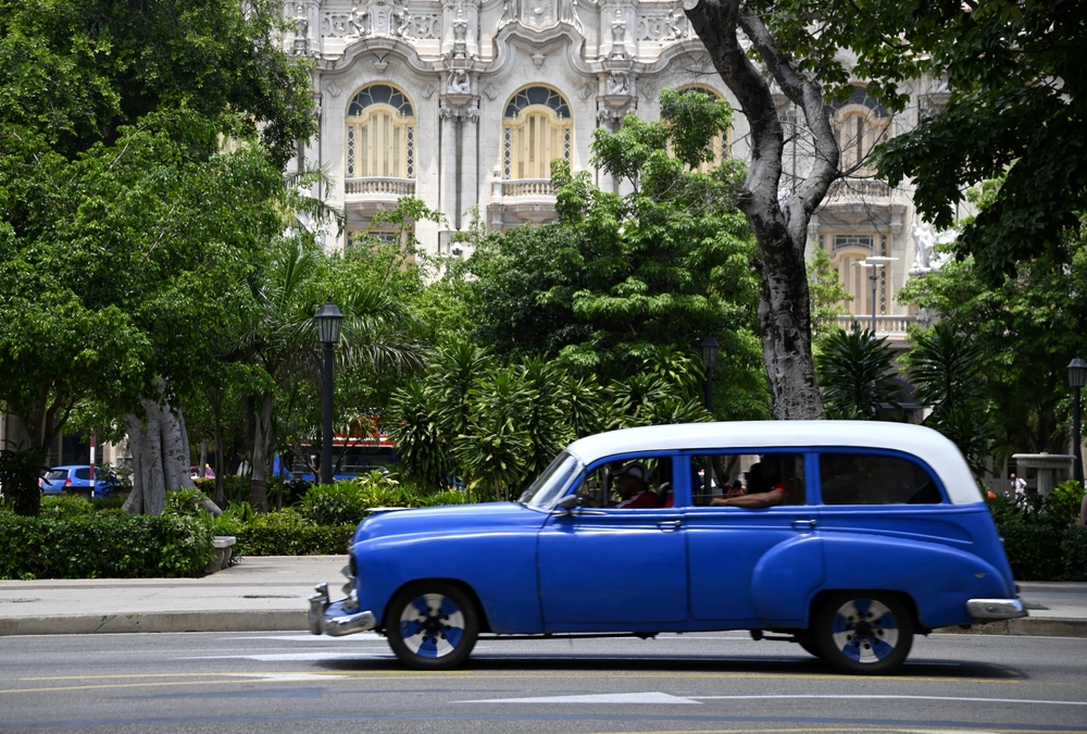 Blaufarbener Oldtimer fährt durch Havana.