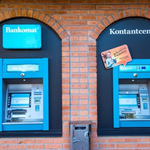 Zwei blaue Bargeldautomaten an Klinkerhaus