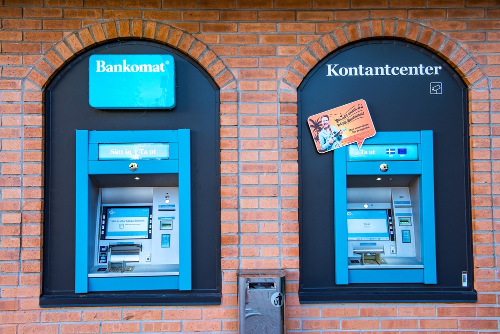 Zwei blaue Bargeldautomaten an Klinkerhaus