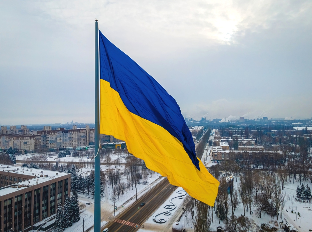 Ukrainische Flagge vor winterlicher Stadt