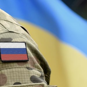 Uniform mit russischem Emblem vor ukrainischer Flagge