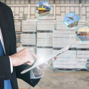 Logistikkonzept mit Geschäftsmann, der digitale Tablet-Versandsymbole hält, die für Import, Export und logistischen Hintergrund verwendet werden.