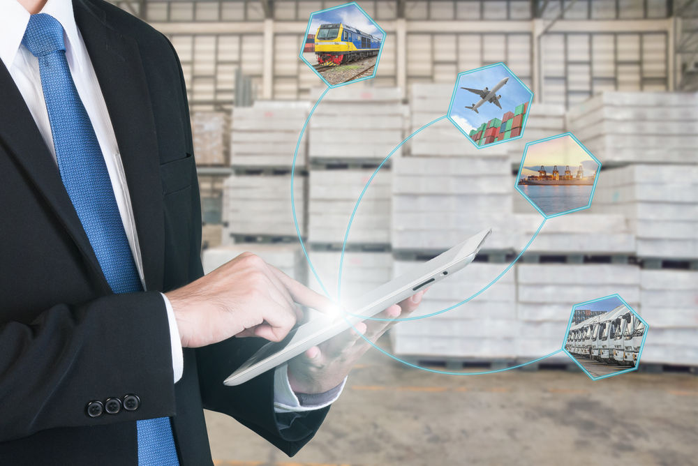 Logistikkonzept mit Geschäftsmann, der digitale Tablet-Versandsymbole hält, die für Import, Export und logistischen Hintergrund verwendet werden.
