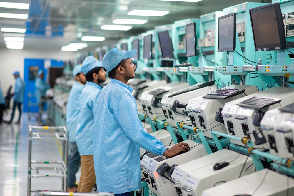 Indische Fabrik mit Beschäftigten an Bildschirmen